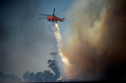 A helicopter dumping fire retardent over a property after a spot fire destroyed stored bails, Kangaroo Island, South Australia, 13 January 2020 / Jeremy Piper