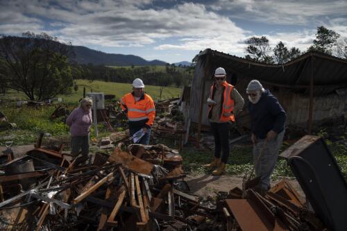 Jim Humphries and Ined Humphries and two workers planning to remove the rubble on their property destroyed from the bushfires, Cobargo, New South Wales, 4 May 2020 / Matthew Abbott