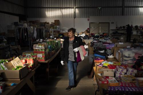 Volunteer Liz Martin at the Cobargo Relief Centre carrying donated clothes to a local resident affected by the bushfire crisis during the COVID-19 pandemic, Cobargo, New South Wales, 5 May 2020 / Matthew Abbott