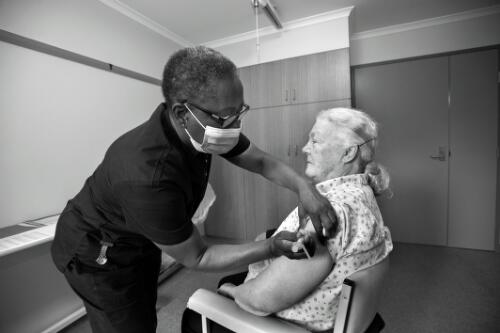 Trentham Aged Care resident Margaret Wheeler receiving the AstraZeneca vaccine from nurse Akua Ed Nignpense from Grampians mobile vaccination team, part of Ballarat Health Services, Trentham, Victoria, March 2021 / Sandy Scheltema
