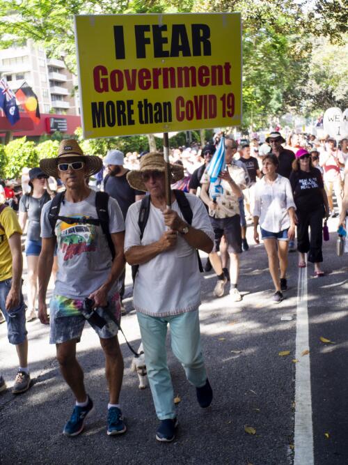 Protesters walking and holding placards at the rally against COVID-19 related public health measures, Brisbane, 20 November 2021 / Hamish Cairns