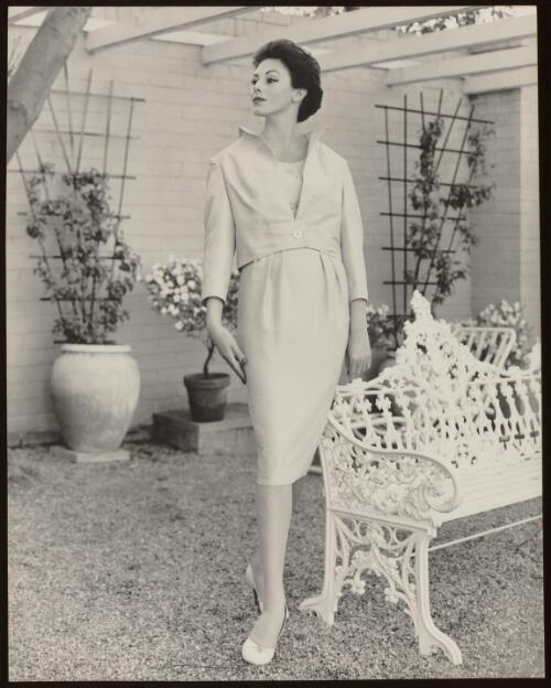 Model standing in a courtyard, approximately 1964 / Athol Shmith