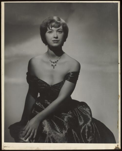 Penelope Munday wearing an off the shoulder silk dress, approximately 1950 / Athol Shmith