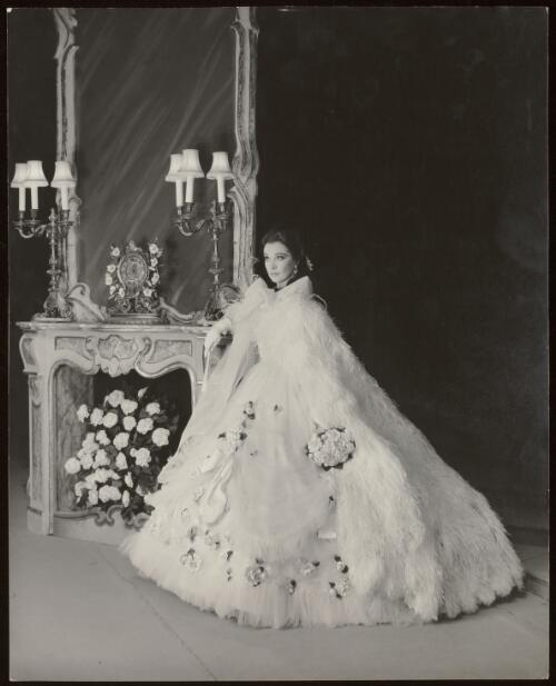 Vivien Leigh in a crinoline gown decorated with camellias with a cape, 1961 / Athol Shmith