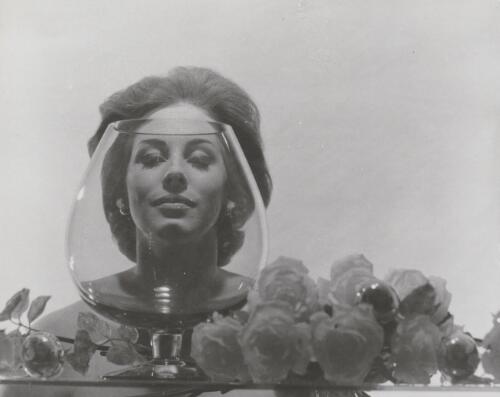 Fashion model posing behind a glass, approximately 1968, 1 / Athol Shmith