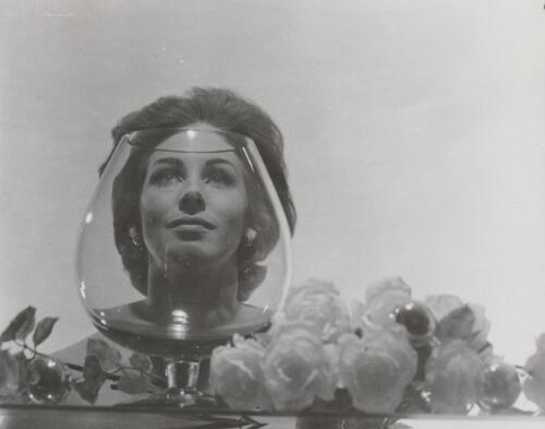 Fashion model posing behind a glass, approximately 1968, 2 / Athol Shmith