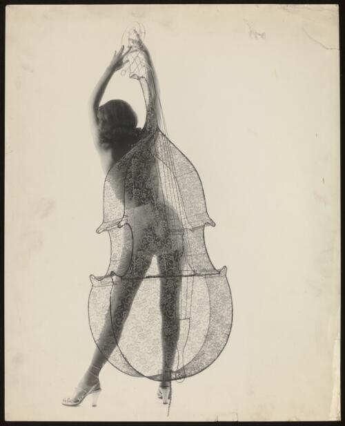 Female model posed behind a wire framed double bass covered in lace / Athol Shmith