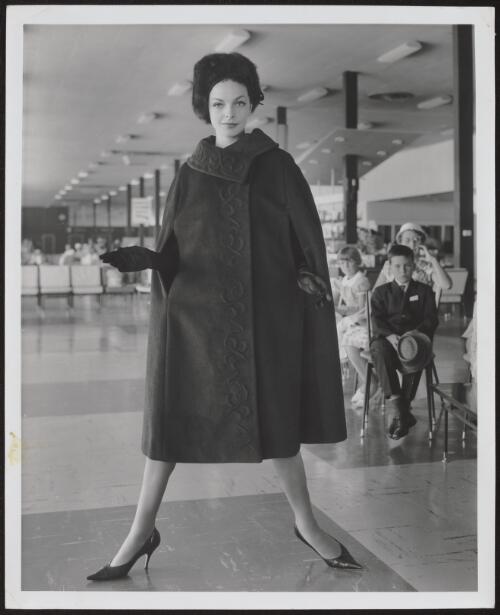 Dawn Didrickson wearing an embroidered cape and a fur hat, approximately 1960, 1 / Athol Shmith