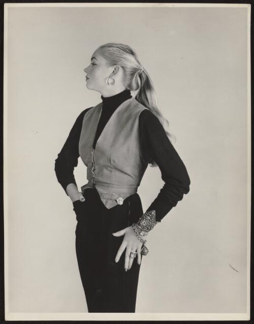 Model with long hair wearing a corduroy waistcoat and silver jewelry, approximately 1970 / Athol Shmith