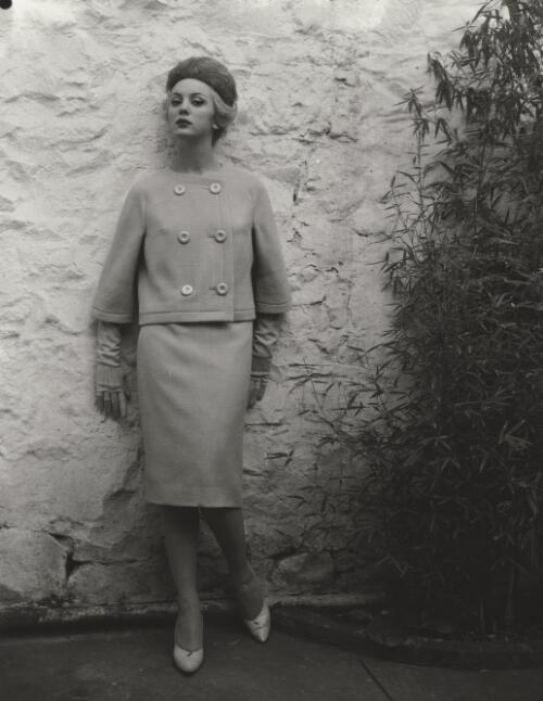 Fashion model posing against wall, approximately 1968, 2 / Athol Shmith