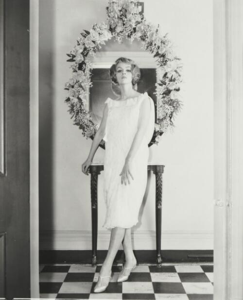 Fashion model standing in front of a mirror, approximately 1965, 1 / Athol Shmith