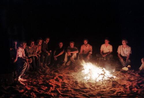 Journalists sitting around a camp fire, Maralinga, South Australia, 1984 / Neil Johnston