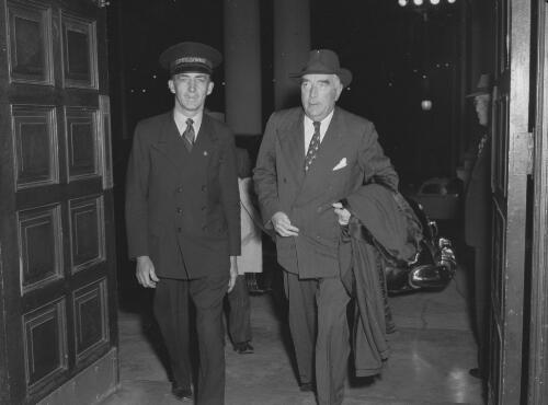 Sir Robert Menzies and a commissionaire entering the City Hall building, Newcastle, New South Wales, 20 April 1951