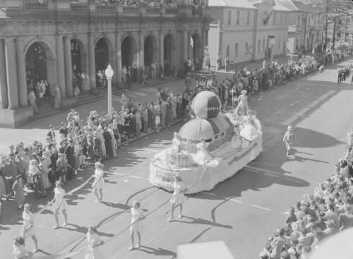 Crowds watching a parade float being pulled along by a group of women during celebrations for the Jubilee of the Commonwealth of Australia, Hunter Street, Newcastle, New South Wales, 1951