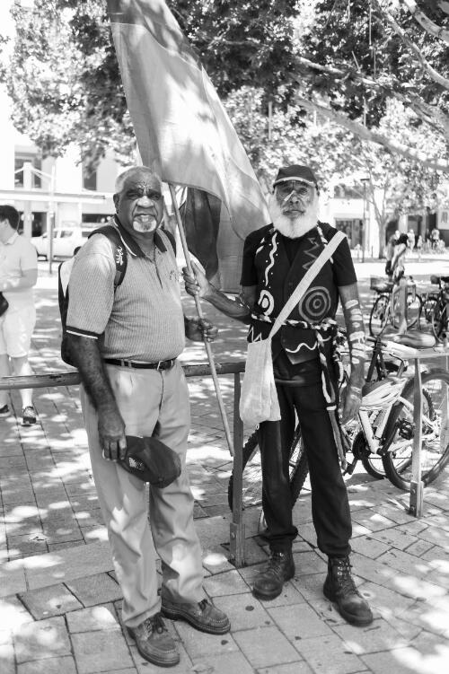 Two Aboriginal Australian men holding a flag during the day of mourning march on Australia Day, Garema Place, Canberra, 26 January 2018 / Sean Davey