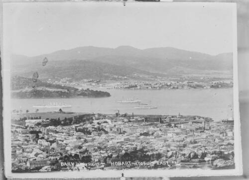 Aerial view of buildings and warships at a distance on the River Derwent during the Royal tour by Edward, Prince of Wales, Hobart, Tasmania, 1920, 2 / Harry Baily