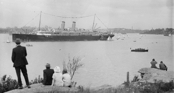 People watching as a steam ship with bunting sails through the harbour, Sydney, ca. 1920s