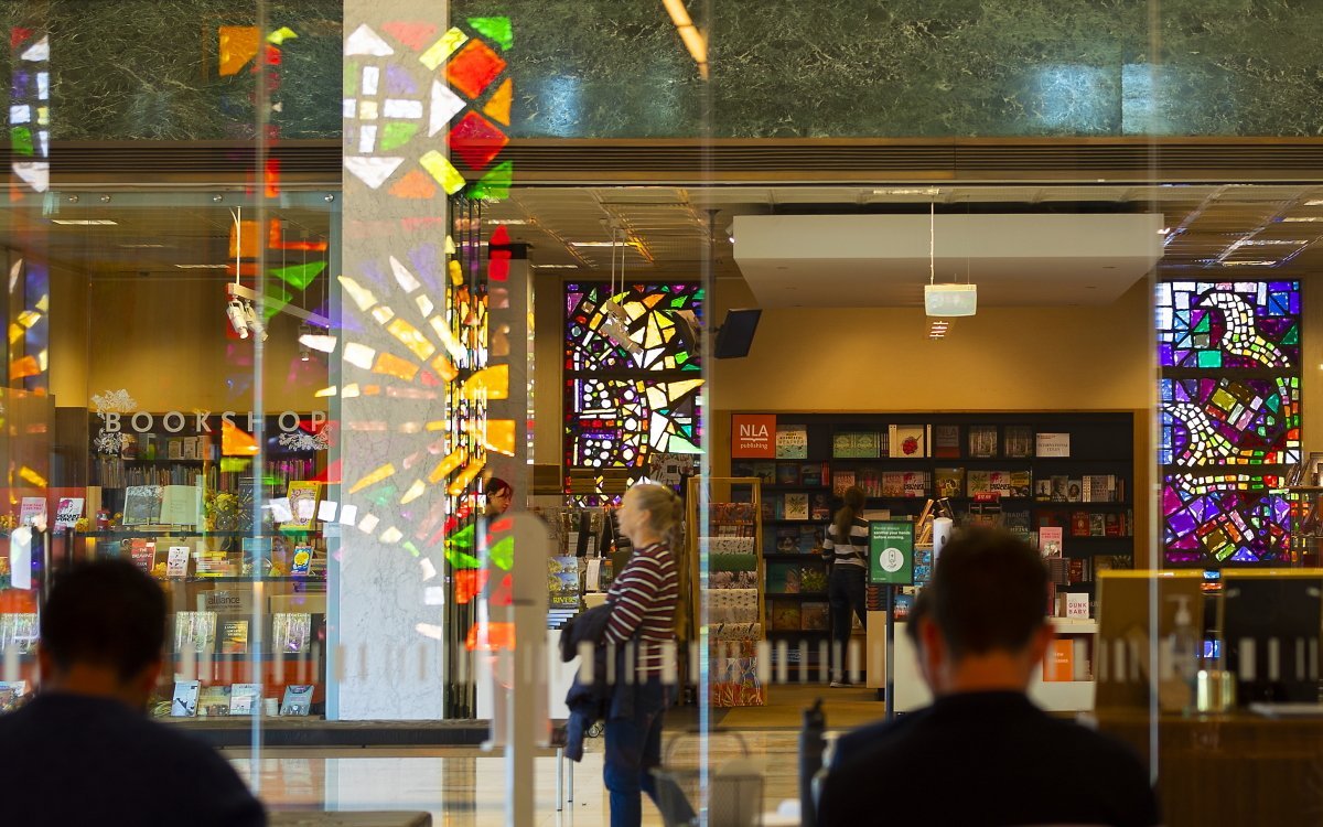 An image of the front of the National Library Bookshop including backshots of passing visitors.
