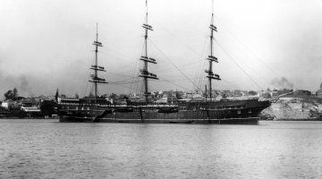 Black and white photo of a large ship in a harbour