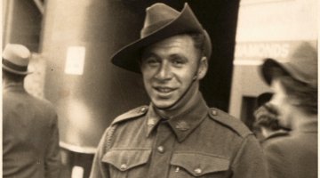 Man in military uniform with hat smiling