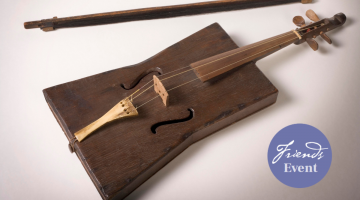 A violin and bow crafted from a stockman's tucker box and a purple sticker signalling that this is a Friends of the Library event.