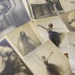 Photographs spread on a table, of a woman throughout her career in ballet, including photos of her dancing and portraits