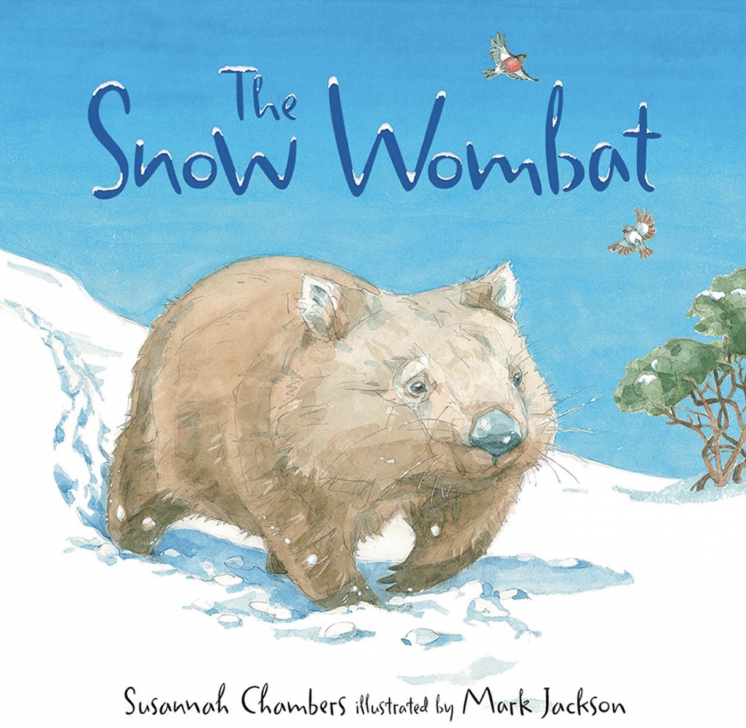 Book cover with blue text reading 'The Snow Wombat' and an illustration of a wombat walking through snow on a bright cloudless day