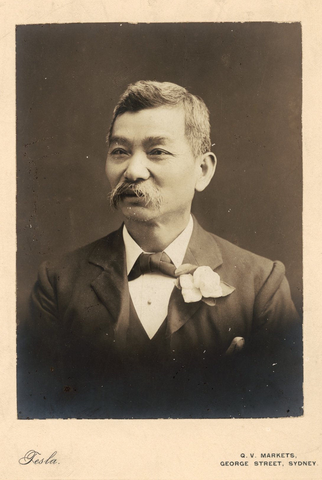Portrait of a Chinese-Australian man with a moustache and wearing a nice suit