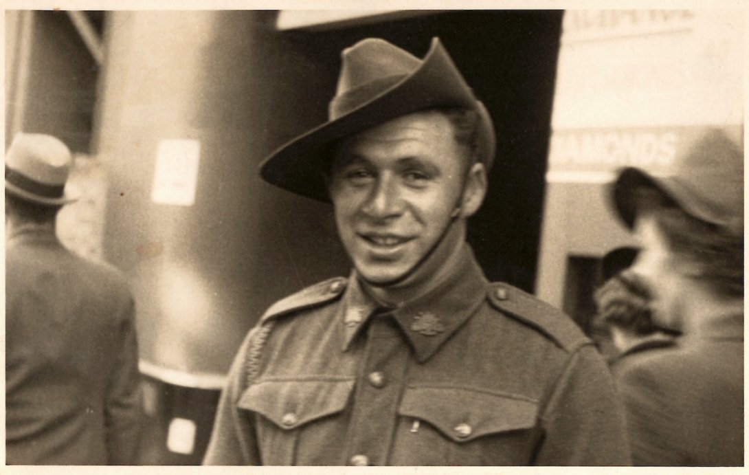 Man in military uniform with hat smiling