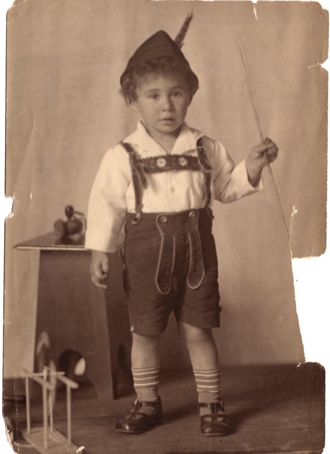 Sepia toned photo of young boy dressed in lederhosen